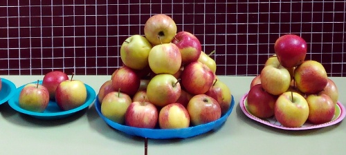 Tres bandejas con apilamientos de manzanas