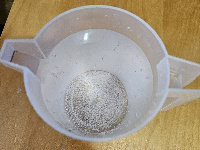 Jarra con un litro de agua y nitrato de potasio sin disolver