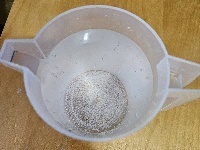Disolución sobresaturada 2 (cREAgal) Jarra con un litro de agua y nitrato de potasio sin disolver.