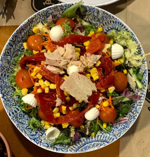 Imagen de una ensalada con tomate, pimiento, lechuga, maíz, queso y atún.