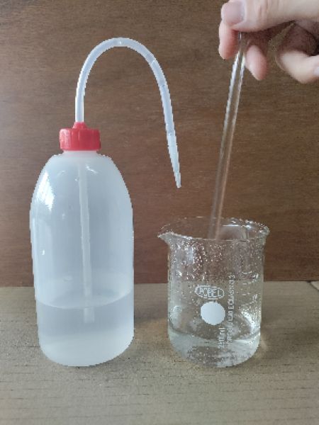 Se remueve con una varilla de vidrio una mezcla de un sólido y agua dentro de un vaso de precipitados.