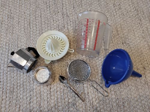 Diversos ejemplos de utensilios de cocina: exprimidor, cafetera, embudo, vaso medidor, colador y cucharilla.