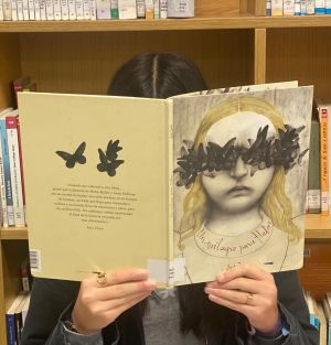 Una persona leyendo en una biblioteca