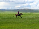 Fotografía dunha persoa a cabalo na estepa de Mongolia