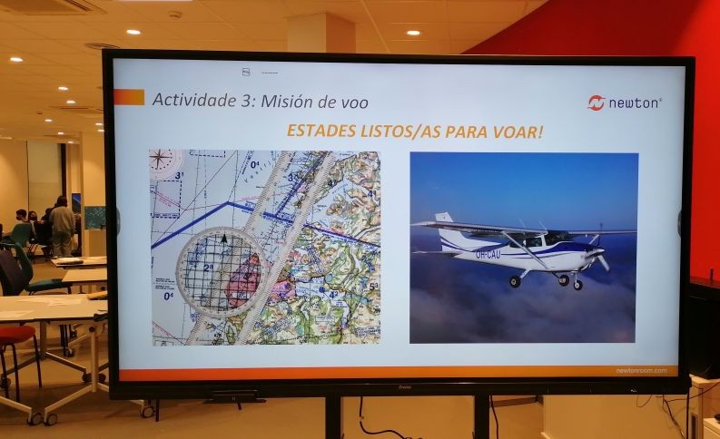 Imagen del Aula Newton con una pantalla de información sobre la actividad de vuelo y personas al fondo