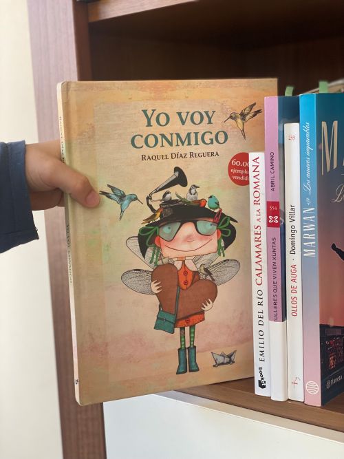 Cogiendo libro yo voy conmigo de una estantería