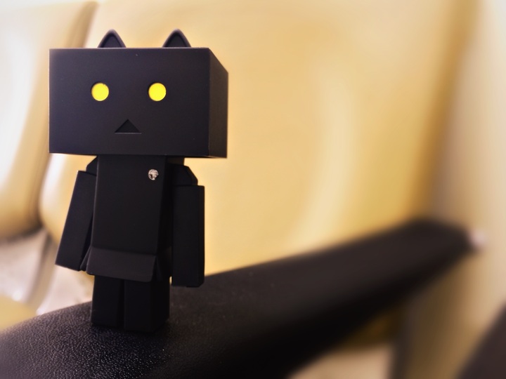 Una especie de robot de color negro con ojos amarillos y orejitas, simulando un gato.
