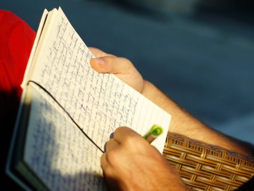 Una mano con un bolígrafo escribiendo sobre un cuaderno