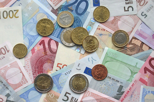 Imaxe de moedas e billetes bancarios que representan a activiade económica.