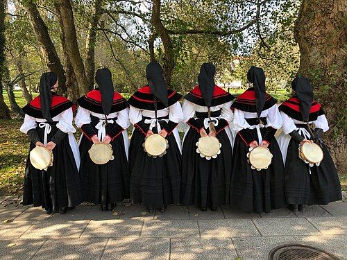Varias pandereteiras vestidas co traxe tradicional de espaldas.