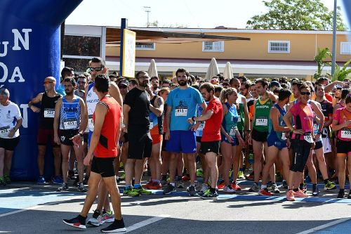 Línea de salida en un carrera popular multitudinaria, donde corredores y corredoras se relajan antes del pistoletazo de salida