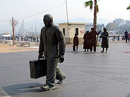 Monumento dunha familia despedíndose dun home cunha maleta