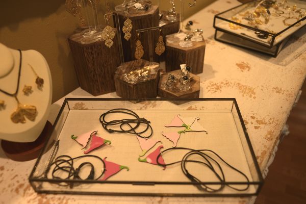Expositor con tres colgantes y cinco broches con forma de  flor.