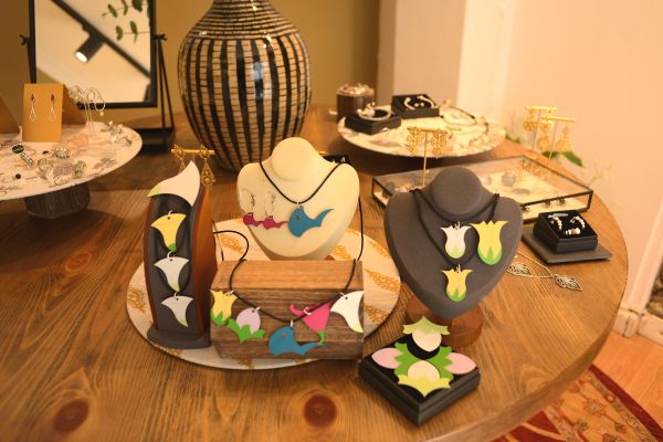 Expositores de joyería con colgantes, broches y pendientes realizados en madera pintada.