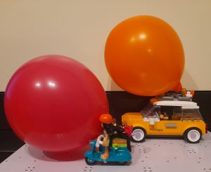 Coche y moto propulsados por globos (cREAgal) Imagen de un coche y una moto de juguete con globos encima de cada uno de ellos para que sean propulsados al soltar el aire de los globos.