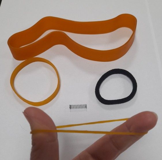 Imagen de dos gomas elásticas, una goma de pelo y un muelle de un bolígrafo