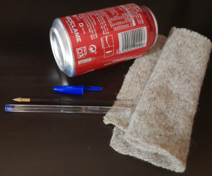 Imagen de una lata vacía, un bolígrafo y un trapo.