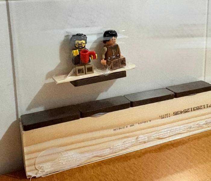 Imagen de un tren de levitación magnética casero con los raíles de madera, los imanes y los personajes de playmovil.