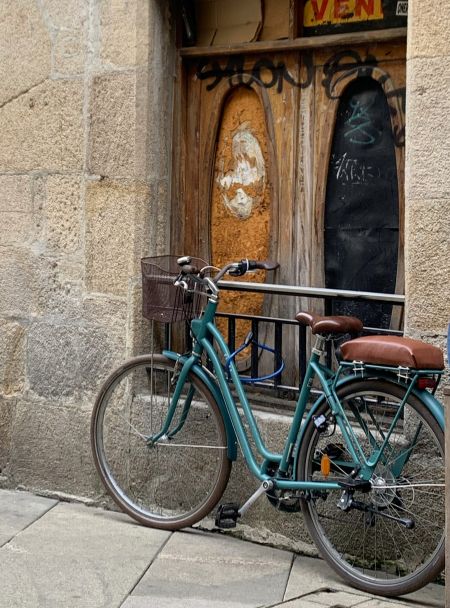 Imagen de una bicicleta de paseo apoyada en una pared. 