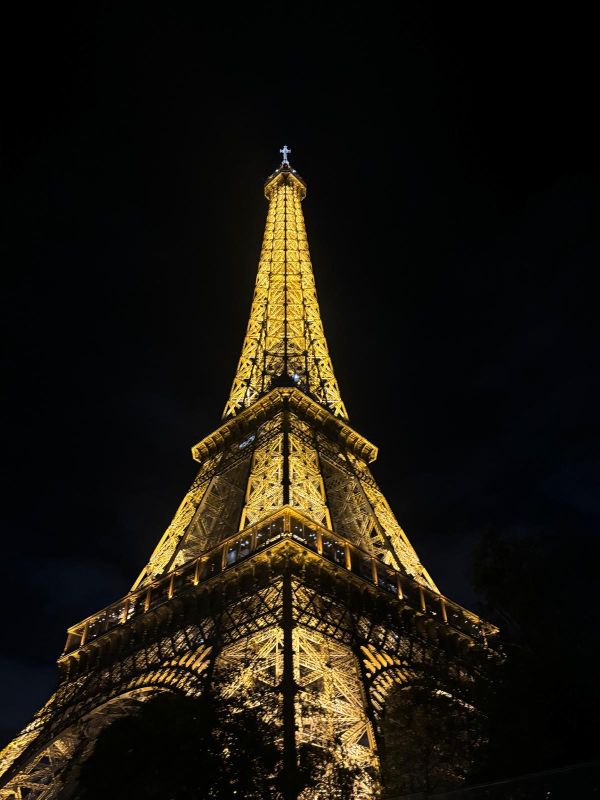 Imagen de la torre Eiffel de París iluminada de noche.